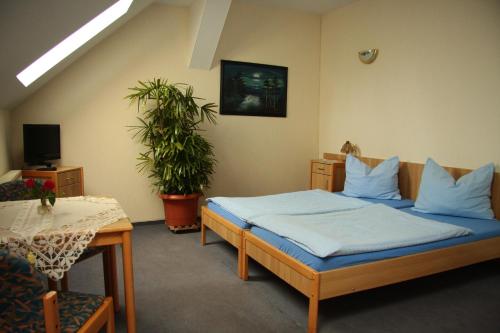 Un dormitorio con una cama con sábanas azules y una mesa. en Werners Landgasthaus en Lieskau