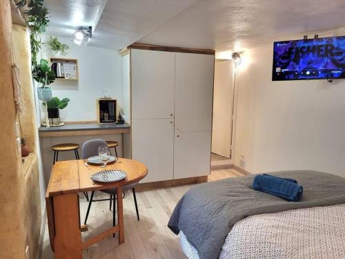 Cet appartement comprend une chambre avec une table et un lit ainsi qu'une cuisine. dans l'établissement studio cosy rdc centre Laval vu château et jardin, à Laval