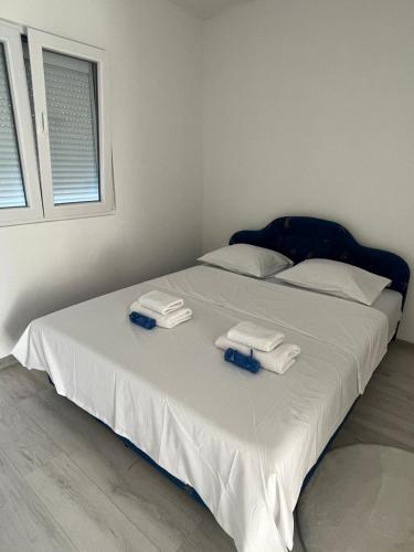 a white bed with towels on top of it at Knežević apartman in Podgorica
