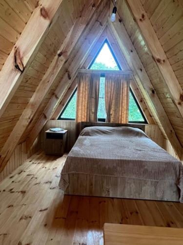 a bedroom in a log cabin with a large window at Cozy Cottage Dilijan Arm in Dilijan