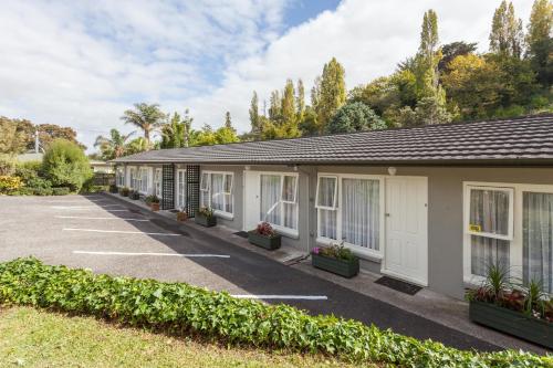 a row of cottages in a parking lot at Brookby Motel in Thames