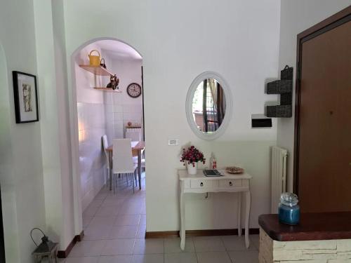 a white hallway with a table and a mirror at Casa vacanze Monterenzio Bologna in Monterenzio