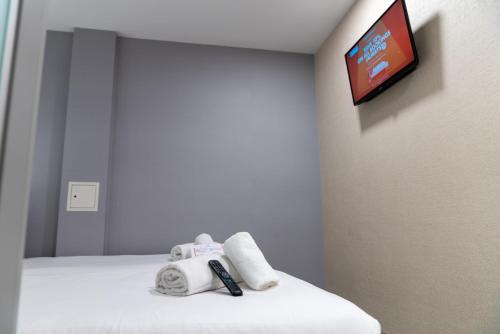 a room with a bed with a teddy bear and a tv at easyHotel Ipswich in Ipswich