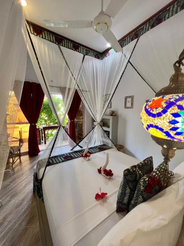 a bedroom with a bed with a canopy at Gadea Boutique Hotel& Gadea Garden Italian Restaurant in Jambiani