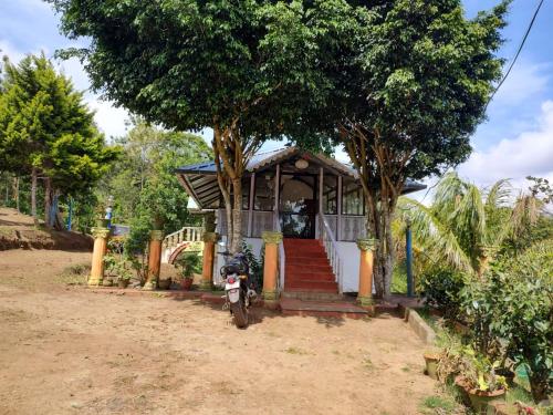 a small house with a motorcycle parked in front of it at Punarjani Ayurvedic Resorts in Ramakkalmedu