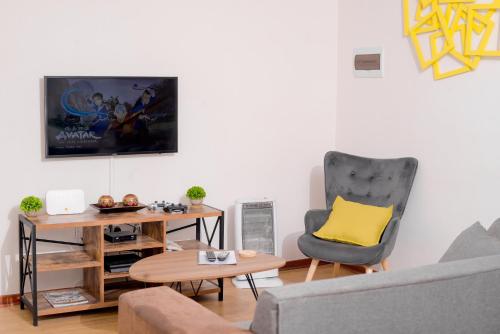 ein Wohnzimmer mit einem Sofa und einem Stuhl in der Unterkunft Entire 2 Bed, 5 mins 2 Game City, Netflix & Ps4 in Gaborone