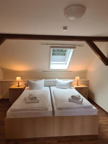 two beds in a small room with a window at "Spreehof" Apartmenthaus in Lehde in Lübbenau