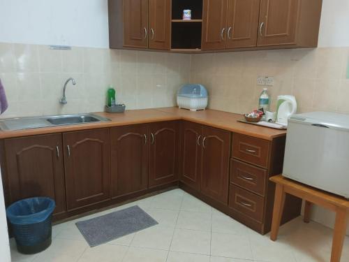 a kitchen with wooden cabinets and a sink at My Getaway Home @Marina Cove in Lumut