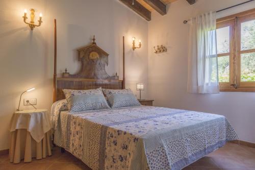 ein Schlafzimmer mit einem Bett und einer Uhr an der Wand in der Unterkunft Maravillosa casa Ses Comes con piscina in Selva