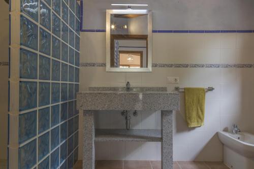 ein Bad mit einem Waschbecken und einem Spiegel in der Unterkunft Maravillosa casa Ses Comes con piscina in Selva