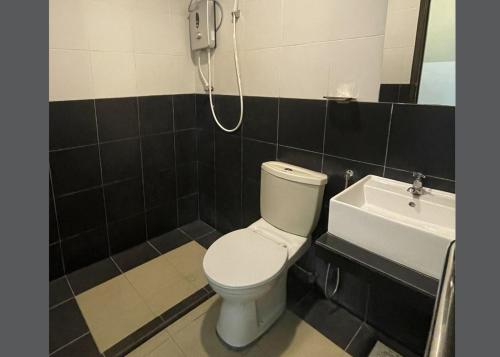 a bathroom with a toilet and a sink at JQ Suria Hotel in Lahat