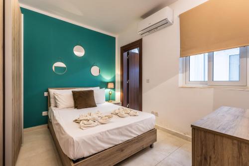 a bedroom with a bed with a green wall at Kunsu's Apartment 5 min walk from St Julians in San Ġwann
