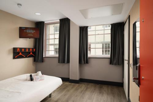 a room with two beds and two windows at easyHotel Ipswich in Ipswich
