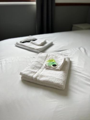 a white towel is sitting on top of a bed at Stay Inn Express, Cambridge in Cambridge