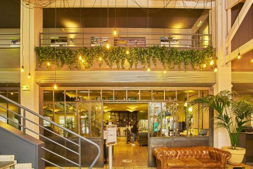 a lobby of a building with a couch and plants at Sporting House Hôtel in Toulouse