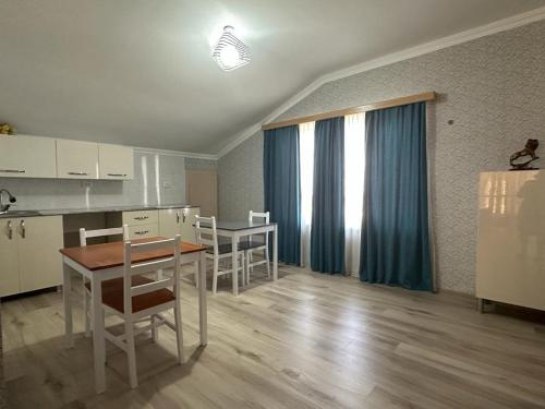 a kitchen and dining room with a table and chairs at Happy House in Kutaisi