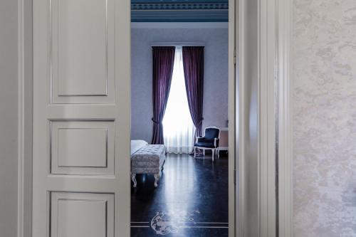 a door leading to a room with a window at Palazzo Favacchio - Patanè in Scicli