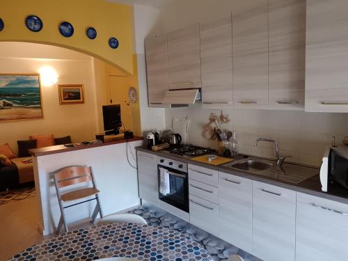 a kitchen with white cabinets and a stove top oven at Relax al mare in Borgio Verezzi