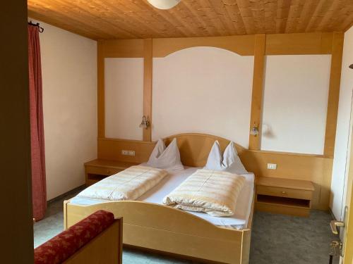 ein Schlafzimmer mit einem Bett mit zwei Kissen darauf in der Unterkunft Garni Rika in Partschins