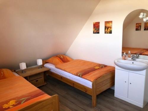 um quarto com 2 camas individuais e um lavatório em Haus am Meer 9082 - Fehmarn em Fehmarn