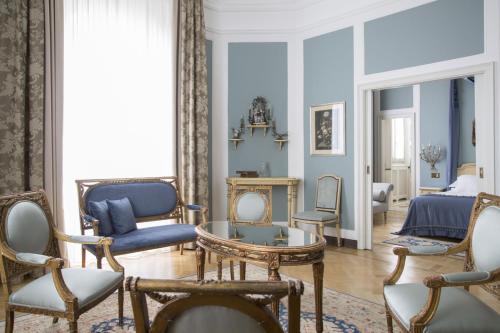 a living room with blue walls and chairs at Grand Hotel et de Milan - The Leading Hotels of the World in Milan
