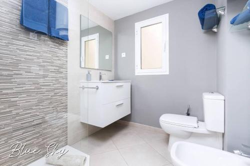 een witte badkamer met een toilet en een wastafel bij Corralejo Sun 335 Blue Sky by Rentalfue in Corralejo