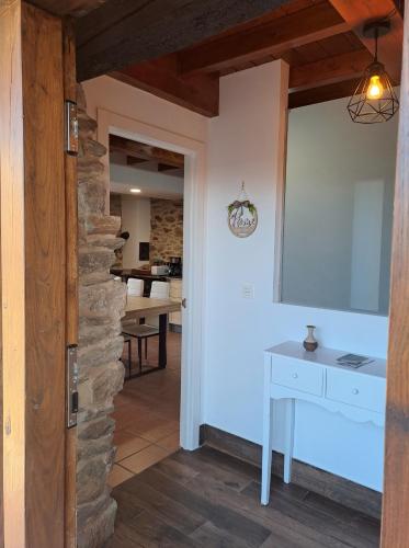 a room with a stone wall and a white table at CASA ARABIA in Monforte de Lemos