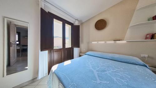 a bedroom with a bed with a blue blanket at Appartamento La Vigna 3 in Badesi