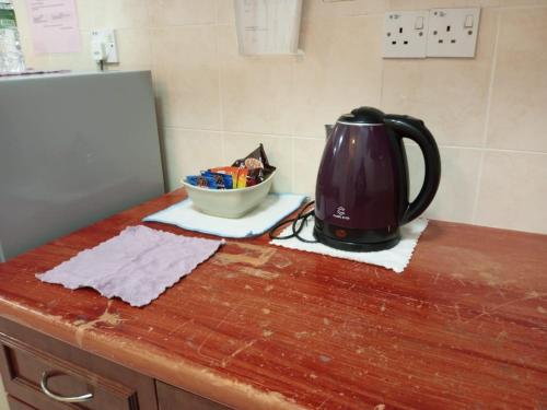 a tea kettle sitting on top of a wooden counter at My Getaway Home @Marina Cove in Lumut