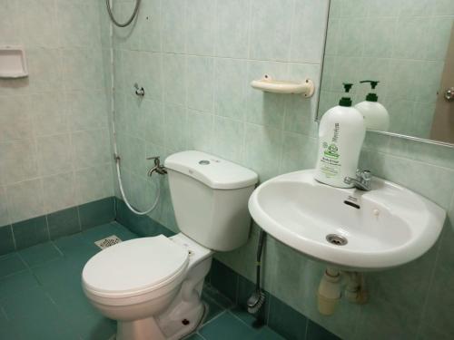 a bathroom with a toilet and a sink at My Getaway Home @Marina Cove in Lumut