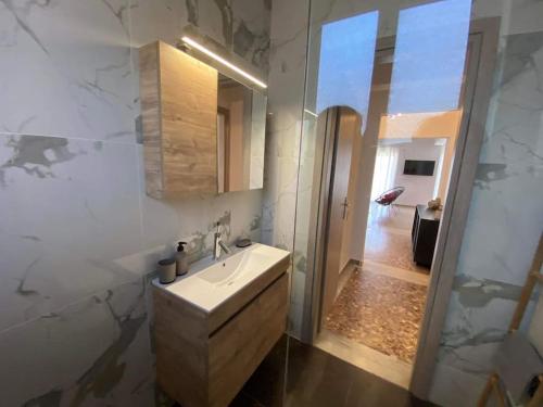 a bathroom with a sink and a mirror at NEW! Flower Patio House 2 BDR - BBQ - Wash machine in Lávrion