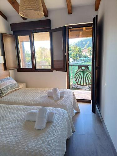 a bedroom with two beds and a balcony with a view at CASA ARABIA in Monforte de Lemos