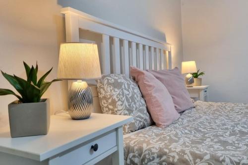 a bedroom with a bed with a lamp and pillows at Finnem Rentals Kyjevská in Prague