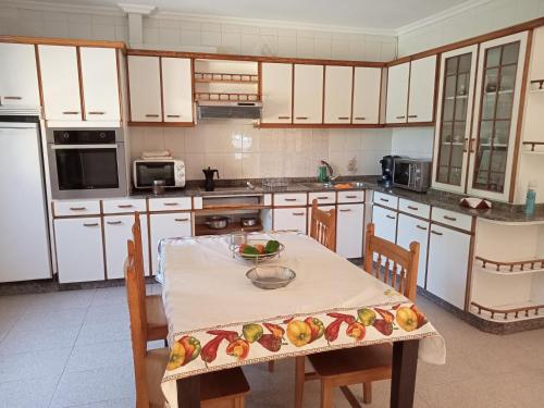 een keuken met een tafel en een fruitschaal bij Casa da Fariñeira in Redondela