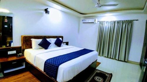 una camera da letto con un letto grande con cuscini blu di Collection O Ziva Resort Near Calangute Beach a Calangute