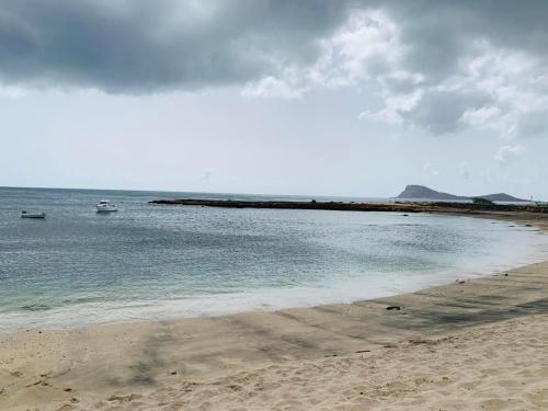 a beach with two boats in the water at Casa Mar e Sol - Murdeira - Ilha do Sal in Palha Verde