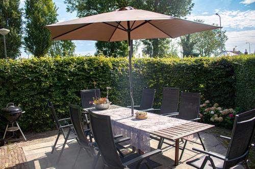 a table with an umbrella on a patio at de Staelduinhoeve in 's-Gravenzande