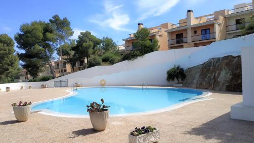 uma piscina em frente a um edifício em Apartamento en el campo de golf Son Parc, Menorca em Son Parc