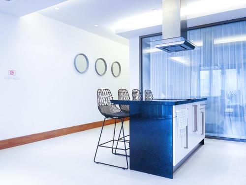a kitchen with a blue counter and chairs at Beachfront 2br 2bath apartment private plunge pool 50 meter to Naithon beach in Nai Thon Beach