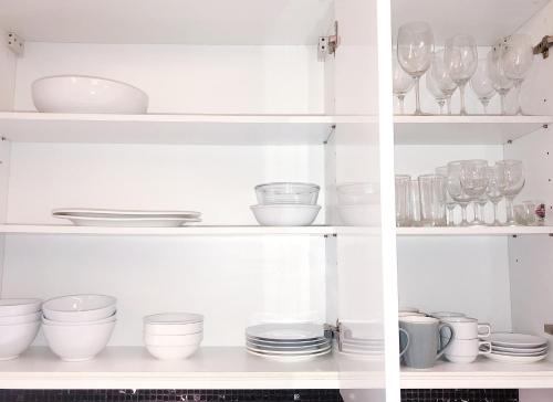 a white cabinet filled with dishes and glasses at Beachfront 2br 2bath apartment private plunge pool 50 meter to Naithon beach in Nai Thon Beach