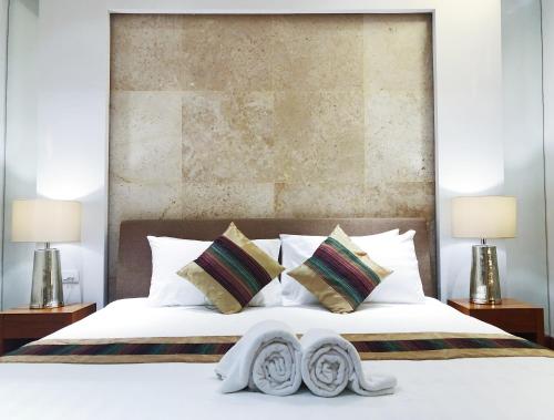 a bedroom with a large white bed with two lamps at Beachfront 2br 2bath apartment private plunge pool 50 meter to Naithon beach in Nai Thon Beach