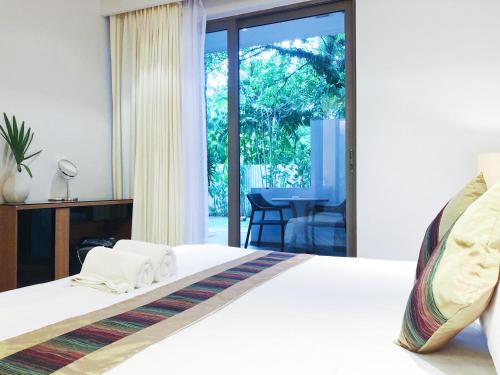 a bedroom with a bed and a sliding glass door at Beachfront 2br 2bath apartment private plunge pool 50 meter to Naithon beach in Nai Thon Beach