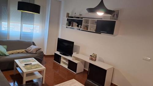 sala de estar con sofá y TV en Apartamento Molino en Almería