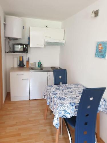 a kitchen with a table and blue chairs and a kitchen with a counter at Apartma Patricija for 2 in Tolmin