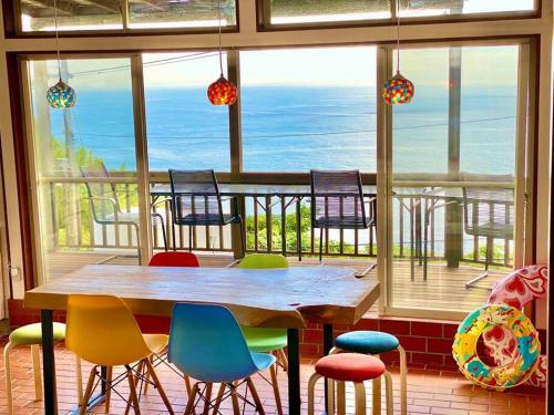 a table and chairs in a room with a view of the ocean at 露天風呂オーシャンビューBlue Ocean IZU in Ajiro