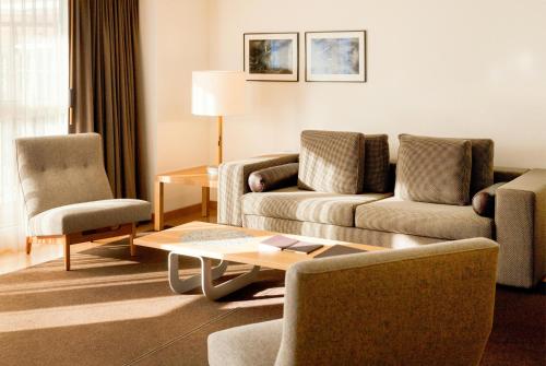 a living room with a couch and chairs and a table at The Omnia in Zermatt