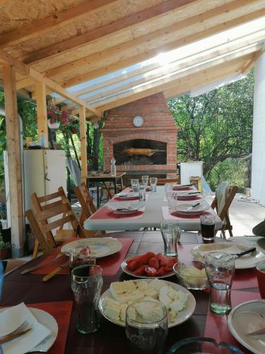 una mesa con platos de comida y chimenea en Kuca radovanovic en Tekija