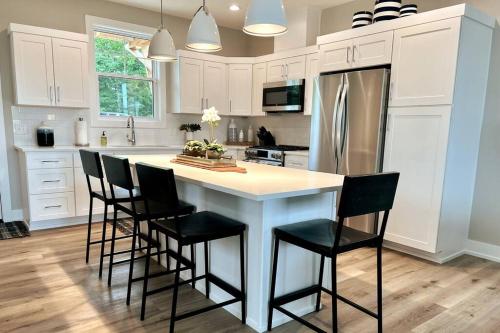 a kitchen with a large island with chairs around it at Hot Tub - Saugatuck - Douglas - Luxury Home Sleeps 8 in Douglas