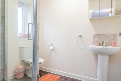 a bathroom with a toilet and a sink and a shower at Modern, Spacious House with Free Parking & Garden in Swindon