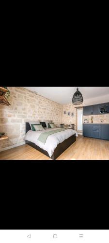 a bedroom with a large bed and a stone wall at IMHOST - Amazing architect studio Père Lachaise in Paris